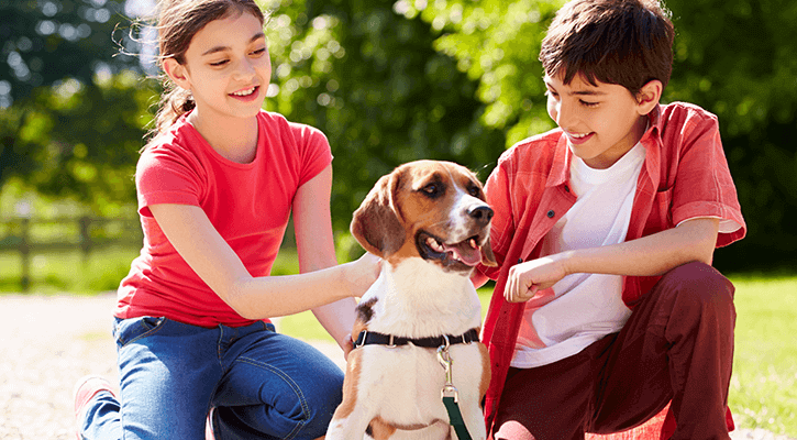 Children holding a dog needing a dog vaccine